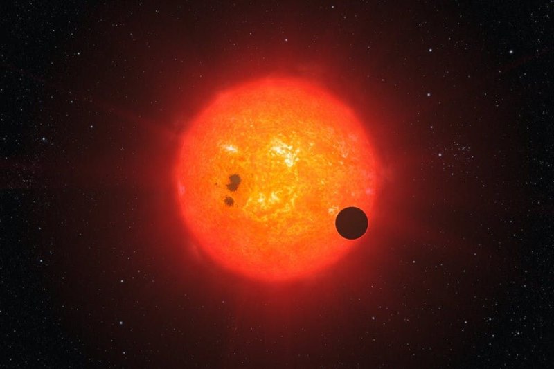 Impresión artística de un exoplaneta en tránsito por una estrella enana roja