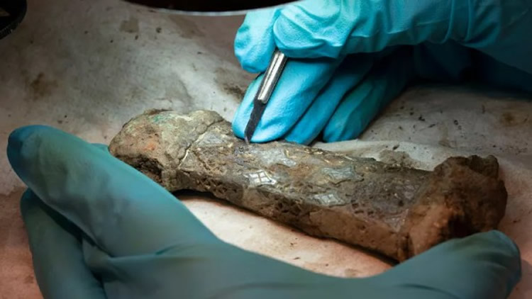 Un investigador examina los restos de la espada