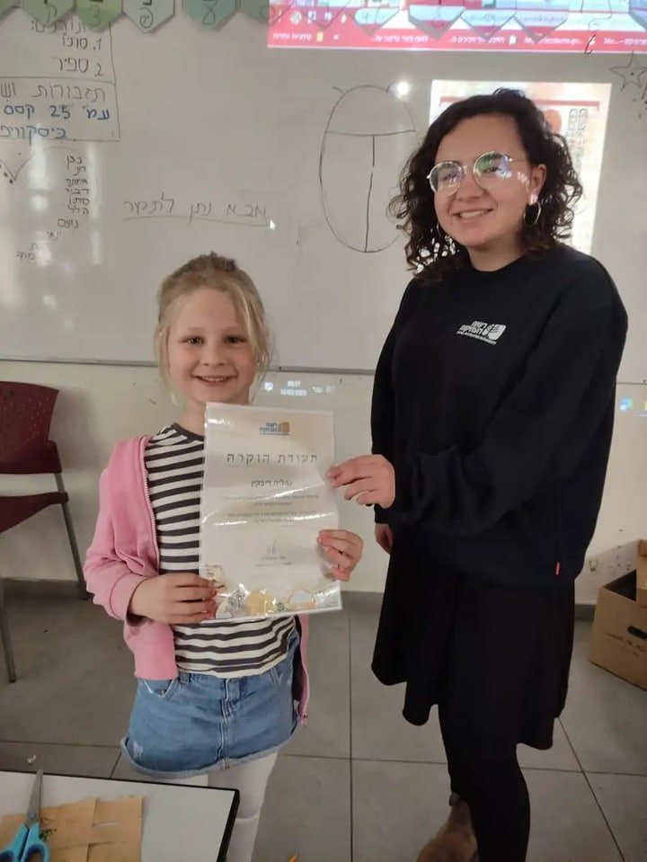 Amalia, junto a su maestra, con su certificado de «buena ciudadana arqueológica»